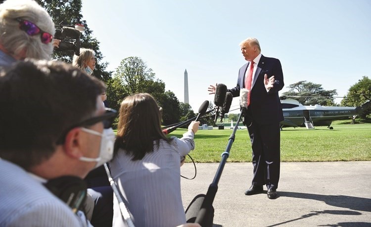 الرئيس دونالد ترامب متحدثا للصحفيين في البيت الابيض قبيل بدء جولة انتخابية على عدد من الولايات أمس	(أ.ف.پ)