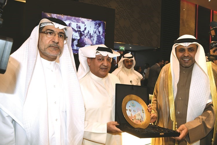 الوزير محمد الجبري يتلقى درعا تذكارية من محمد العواش خلال افتتاح معرض الكويت الدولي 44 للكتاب