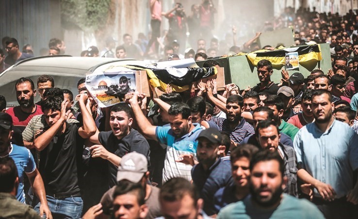 فلسطينيون يشيعون جثامين اعضاء في الجهاد الاسلامي قضوا بغزة أمس	(أ.ف.پ)