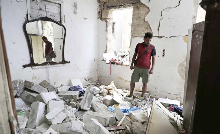  سوري يتفحص منزله المدمرنتيجة انفجار مرفأ بيروت في منطقة الكرنتينا (أ.ف.ب)