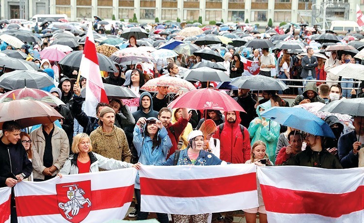 متظاهرون يحملون أعلام بيلاروسيا احتجاجا على نتائج الانتخابات الرئاسية بميدان الاستقلال في مينسك (رويترز)