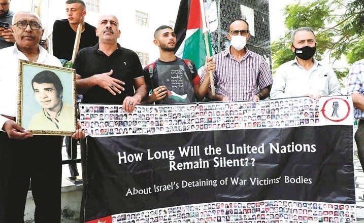 فلسطينيون خلال تظاهرة في مدينة الخليل بالضفة أمس للمطالبة بإعادة جثامين الشهداء المحتجزة لدى الاحتلال (أ.ف.پ)