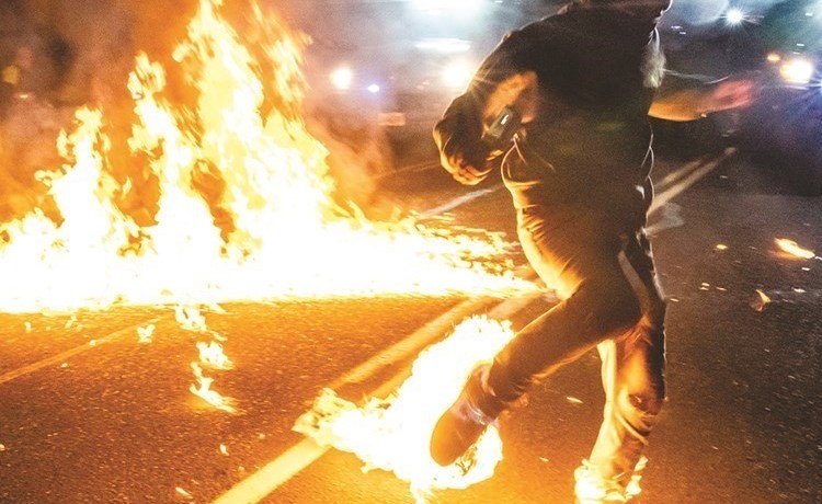 متظاهر اشتعلت النيران بقدمه خلال مواجهات مع الشرطة في مدينة بورتلاند الاميركية	(ا.ف.پ)