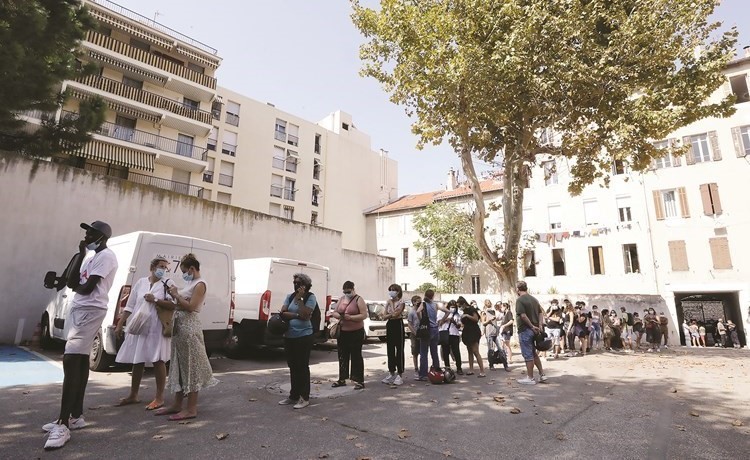 أشخاص يرتدون كمامات ينتظرون في طابور لاجراء اختبار كورونا في فرنسا	(رويترز)