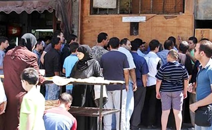 سوريون يتزاحمون أمام احد الأفران		(الانترنت)