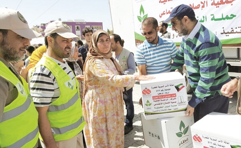 الراحل خلال توزيعه المساعدات لبعض الاسر السورية المهجرة