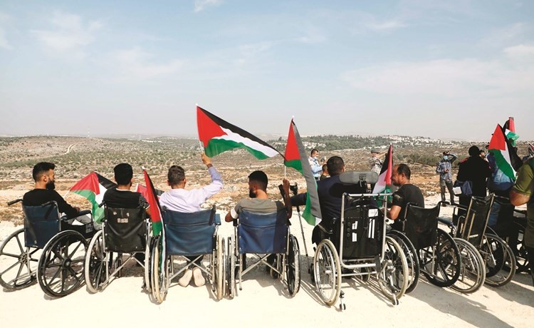 فلسطينيون من ذوي الاحتياجات الخاصة يحتجون على منع الاحتلال إقامة ملعب في بلدة سفليت بالضفة	(ا.ف.پ)