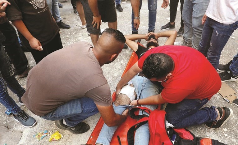 فلسطينيون يسعفون احد الجرحى خلال المواجهات مع قوات الاحتلال برام الله امس	 (رويترز)