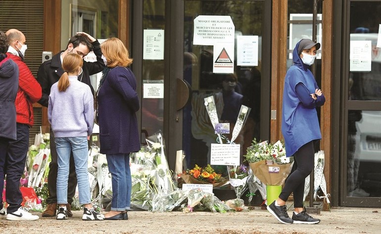 فرنسيون يضعون الزهور أمام كلية بوا دو اولن كونفلانس بعد مقتل المدرس	(رويترز)