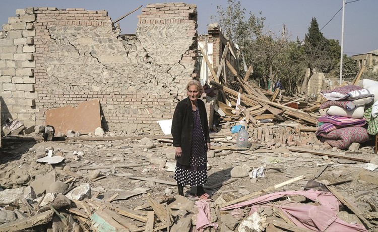 أذربيجانية تقف على أنقاض منزلها الذي أصيب بصاروخ أرميني	(رويترز)
