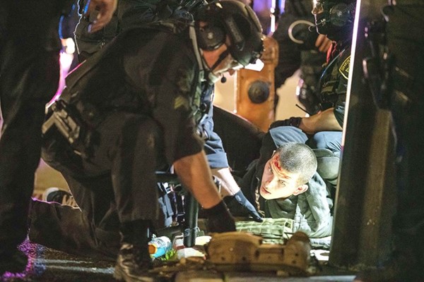 أحد جنود ولاية أوريغون يضرب أحد المحتجين بهراوته أثناء تفريق حشد من متظاهري الكتلة السوداء في بورتلاند 	(أ.ف.پ)
