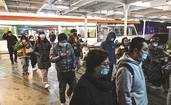 أشخاص يرتدون الكمام كإجراء وقائي ضد ڤيروس كورونا في ووهان بمقاطعة هوبى بالصين	(أ.ف.پ)
