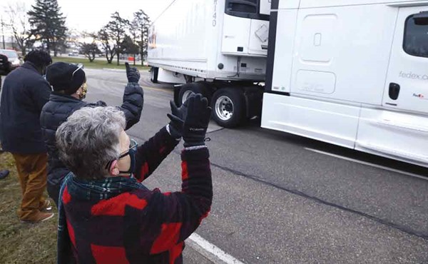 أميركيون يصفقون لشاحنات تحمل أولى جرعات لقاح كورونا لدى مغادرتها مصنع فايزر في ميتشيغان أمس