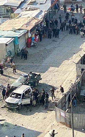 أشخاص يقفون حول سيارة تضررت في انفجار قنبلة في شارع في كابول	 (رويترز)