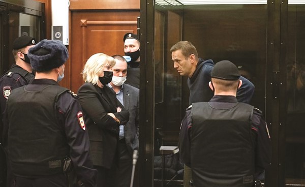 زعيم المعارضة الروسي أليكسي ناڤالني يستمع لمحاميه خلال جلسة استماع في المحكمة امس (أ.ف.پ)