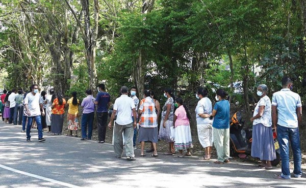 أشخاص ينتظرون التسجيل للحصول على تطعيم ضد ڤيروس كورونا في كولومبر بسريلانكا (أ.ف.پ)