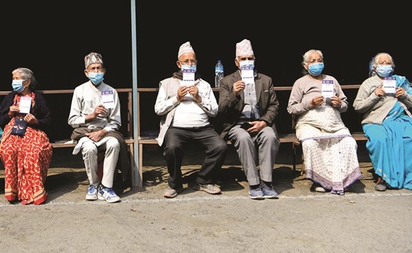 نيباليون يعرضون شهادات التطعيم بعد حصولهم على اللقاح في كاتماندو	(أ.ف.پ)