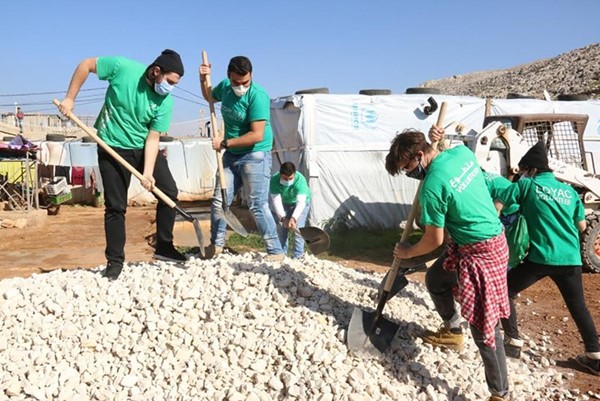 المتطوعون يقومون بتصليحالأرض في مخيم الفاعور