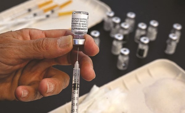 ممرض يحضر جرعة من لقاح فايزر خلال حملة التطعيم في مدينة مونبلييه الفرنسية	(أ.ف.پ)