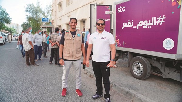 أحمد النويبت من stc وداوود الخراز من فريق تراحم خلال توزيع وجبات رمضان