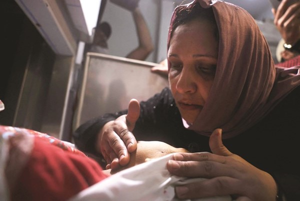 فلسطينية تبكي طفلها الذي قتل في الغارات الاسرائيلية على غزة	(أ.ف.پ)