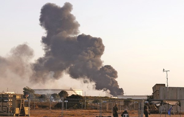 الدخان يتصاعد من خزان نفط أصابه صاروخ من صواريخ الفصائل الفلسطينية في عسقلان	(أ.ف.پ)