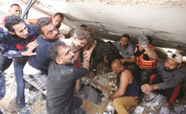 مدنيون وعمال انقاذ ينقذون طفلة من تحت انقاض منزل دمرته غارة اسرائيلية على غزة امس	(رويترز)