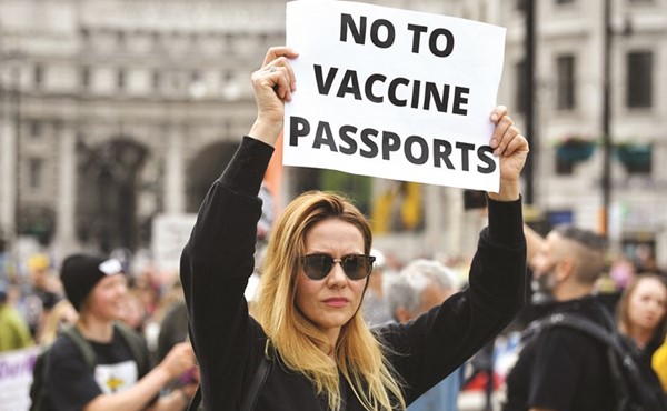 متظاهرة ترفع لافتة ترفض فيها جواز سفر المطعمين خلال مظاهرة متحدون للحرية ضد حملات التطعيم والإغلاق في لندن	(أ.ف.پ)