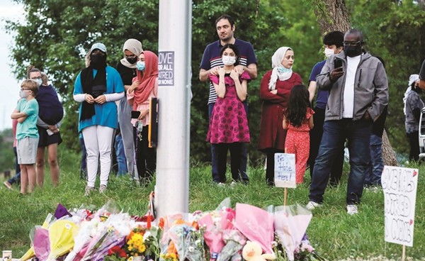 أشخاص يتجمعون عند نصب تذكاري مؤقت في مسرح جريمة مقتل عائلة مسلمة في أونتاريو	(رويترز)