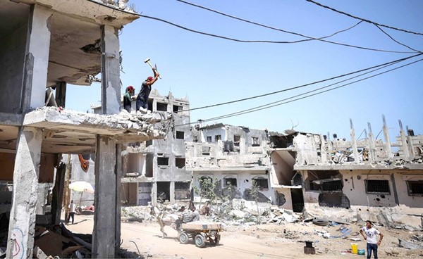 عمال في منزل دمره القصف الاسرائيلي في غزة		(أ.ف.پ)