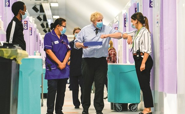 رئيس الوزراء البريطاني بوريس جونسون خلال زيارة لمركز تطعيم في شمال لندن	(رويترز)