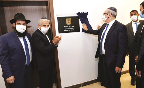 وزير الخارجية الإسرائيلي يائير لابيد مصفقا بعد إزاحة الستار عن اللوحة التذكارية للسفارة في أبوظبي (رويترز)