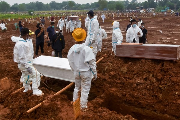 عمال الجنازة يستعدون لدفن ضحايا ڤيروس كورونا في مقبرة بيدورينان العامة في بيكاسي باندونيسيا (أ.ف.پ)