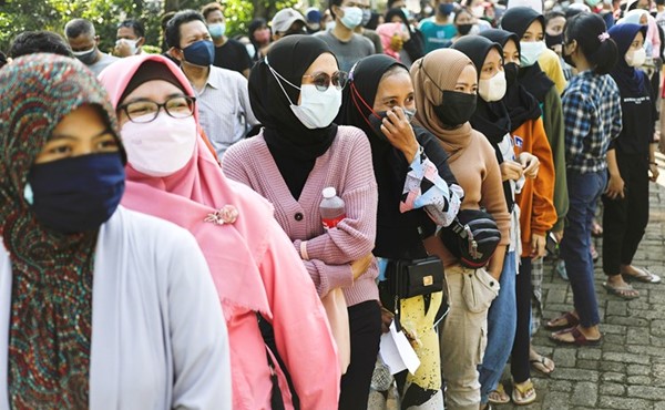 إندونيسيون يصطفون لتلقي جرعة من لقاح كورونا في جاكرتا	(رويترز)