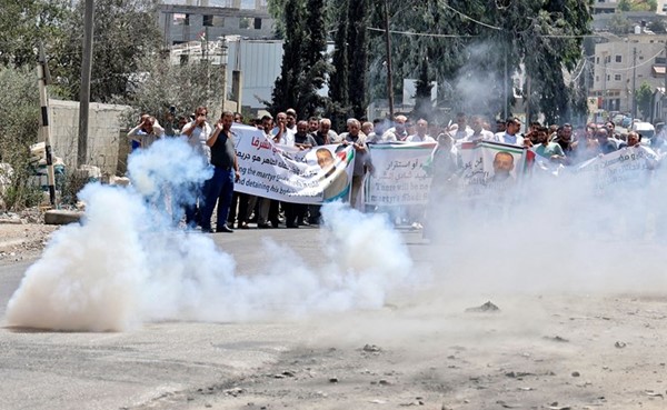 قوات الأمن الإسرائيلية تطلق الغاز المسيل للدموع على متظاهرين عند مدخل قرية بيتا جنوب مدينة نابلس (أ.ف.پ)