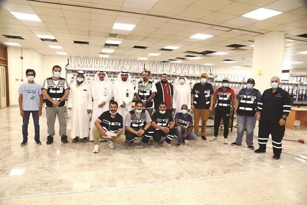 م. ملوح العجمي وم. سلطان العنزي يتوسطان المهندسين والموظفين العاملين على فحص العدادات الذكية