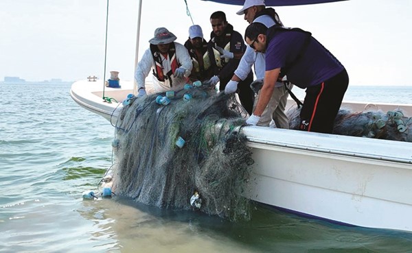 فريق الغوص خلال رفع شباك صيد مهملة من جنوب جون الكويت