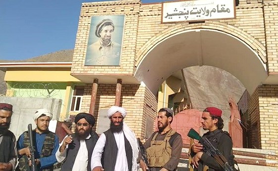 مسلحو طالبان يقفون أمام بوابة حاكم إقليم بانشير الذي استولت عليه الحركة	(رويترز)