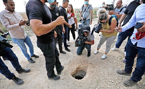 أفراد من الشرطة الإسرائيلية يتجمعون حول نفق خارج سجن «جلبوع» فر منه 6 فلسطينيين     (أ.ف.پ)