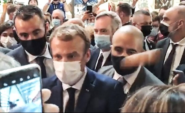 صورة من ڤيديو لحظة القاء محتج بكرة مطاطية تشبه البيضة على الرئيس الفرنسي إيمانويل ماكرون(أ.ف.پ)