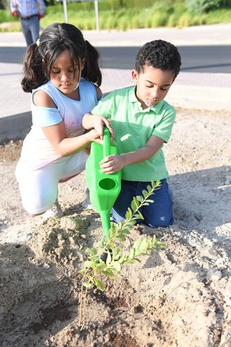طفلان يزرعان شتلة خلال حملة التشجير