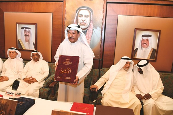 العقيد ركن متقاعد ناصر سالمين يحمل نسخة من عندما كنت أسيرا مهداة إلى صاحب السمو الأمير الشيخ نواف الأحمد