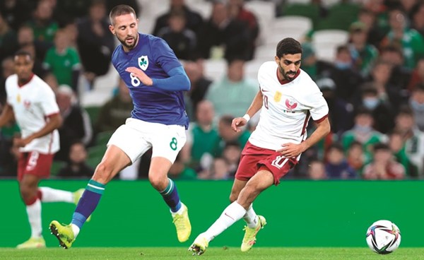 قائد قطر حسن الهيدوس يحاول المرور من لاعب أيرلندا