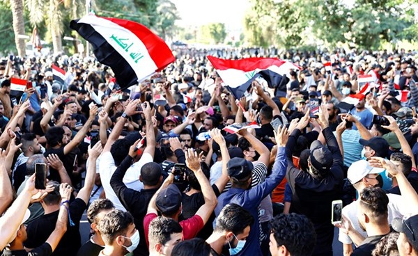 متظاهرون مؤيدون لـالحشد الشعبي يلوحون بالعلم العراقي خلال مسيرة احتجاجية على نتائج الانتخابات أمس	(رويترز)
