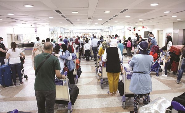 صورة أرشيفية لعدد من المغادرين في مطار الكويت الدولي مع الالتزام بالإجراءات الاحترازية