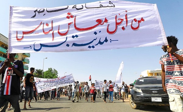 مؤيدون للحكومة السودانية يرفعون لافتة تدعم الحكم المدني خلال تظاهرات بالخرطوم أمس	 (ا.ف.پ)