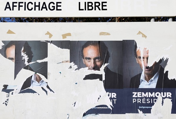 ملصقات ممزقة لدعم المرشح المحتمل للانتخابات الرئاسية الفرنسية اليميني المتطرف إريك زمور (رويترز)