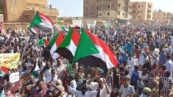 سودانيون يرفعون علم بلادهم ولافتات مناهضة لحكم العسكر خلال "مليونية 30 اكتوبر" (ا.ف.ب)