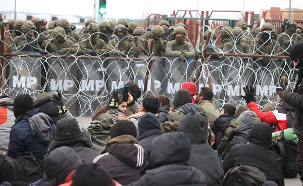المهاجرون العالقون يتجمعون على معبر كوزنكا الحدودي مع پولندا بمواجهة الشرطة الپولندية	 (رويترز)