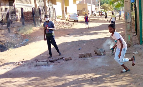  فتى سوداني يهم بإعادة إلقاء قنبلة غاز مسيل للدموع باتجاه قوات الأمن خلال احتجاجات في الخرطوم بحري أمس 		     (أ.ف.پ)